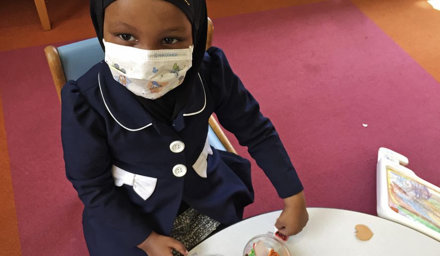 In this Tuesday, May 2, 2017, photo, Amira Hassan, of Burnsville, Minn., plays in the waiting room at the specialty clinic at Children&#39;s Minnesota in Minneapolis. Hassan went to the hospital&#39;s clinic for a routine wellness check, but had to wear a mask to protect her from measles after an outbreak has sickened more than 30 children in Minnesota. The masks are just one precaution that hospitals are taking to try to control the spread of the disease, which is predominantly affecting Minnesota&#39;s Somali community. (AP Photo/Amy Forliti)