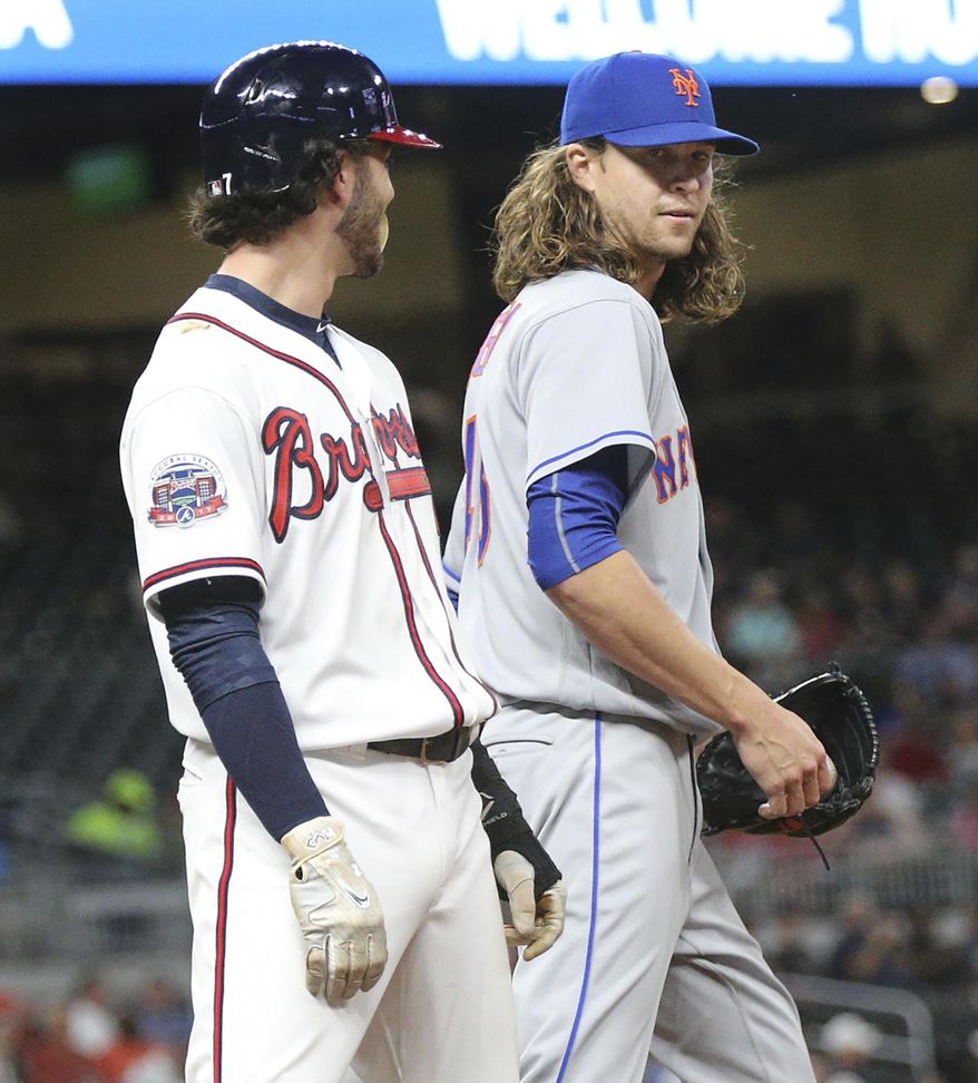 Atlanta Braves' Dansby Swanson and New York Mets' Jacob deGrom face each other down at first base after a single by Swanson during the third inning of a baseball game on Wednesday, May 3, 2017, in Atlanta. (Curtis Compton/Atlanta Journal-Constitution via AP)