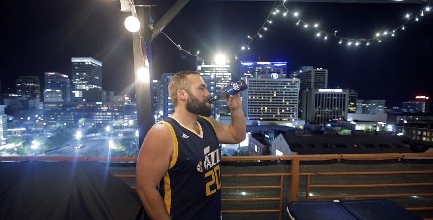 This Tuesday, May 2, 2017, photo, Utah Jazz fan Nick Maneotis, 31, drinks a beer on a roof top deck as his friend watches a Jazz game, in Salt Lake City. Salt Lake City leaders and tourism officials playfully jabbed back at Golden State Warriors players who bemoaned the lack of nightlife in Utah, hoping to combat the predominantly Mormon state's reputation as a boring place where it's tough to get a drink. The tourism agency in the state capital launched a new website and video Monday titled, "There's nothing to do in Salt Lake" that features people enjoying drinks and food at popular breweries, bars, restaurants and sporting venues. (AP Photo/Rick Bowmer)