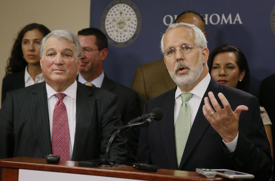 FILE - In this Tuesday, April 25, 2017, file photo, former Oklahoma Gov. Brad Henry, right, gestures as he answers a question during a news conference in Oklahoma City. Henry, one of the co-chairs of the Oklahoma Death Penalty Review Commission, announced the findings of a report that says the state should extend its moratorium on capital punishment. At left is Andy Lester, also a co-chair. (AP Photo/Sue Ogrocki, File)
