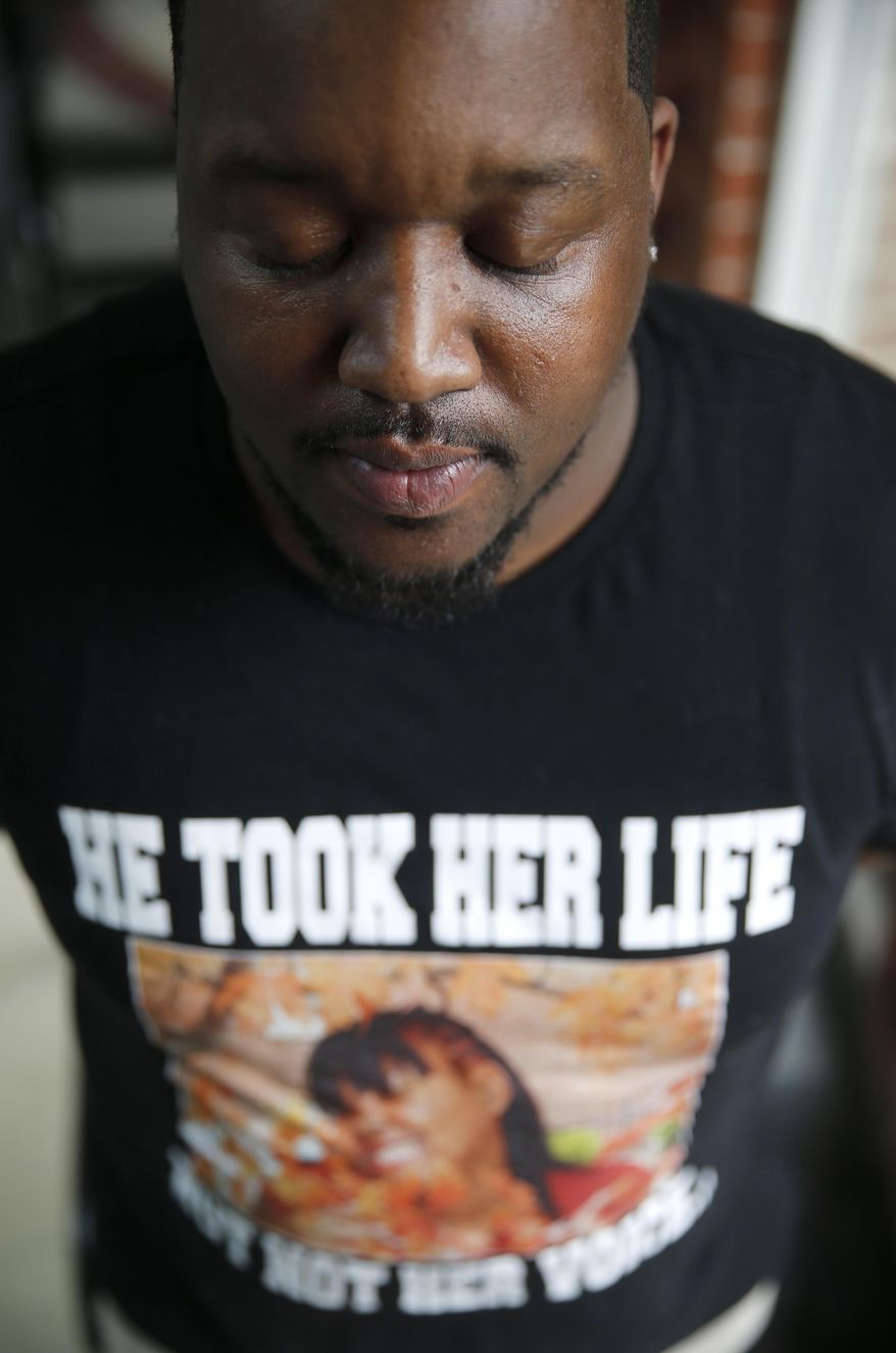 FILE - In this March 4, 2016 file photo, Martinez Sutton wears a shirt commemorating his sister, Rekia Boyd, 22, who was shot and killed in 2012 by Chicago police officer Dante Servin. Servin resigned in May 2016 after the police superintendent said he should be fired for killing Boyd, 22, an unarmed black woman, four years earlier. Servin was off-duty during the incident. She had been walking down a street with her friends when he told them to be quiet, and he fired when he thought he saw a gun. Prosecutors charged Servin with involuntary manslaughter, a judge acquitted him in April 2016, saying he'd been improperly charged. The city settled a wrongful-death lawsuit in 2013 with Boyd's family for $4.5 million. (AP Photo/Charles Rex Arbogast)