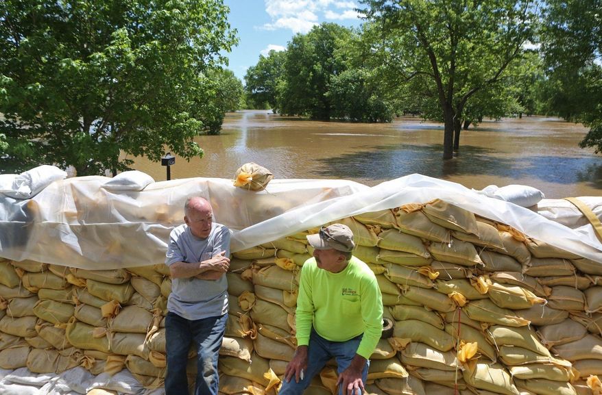 Homeowner Tom Bell, 71, left, and his friend Stan Erlinger take a break from sandbagging and flood preparation on Tuesday, May 2, 2017, in Fenton, Mo. Bell is hoping that he is better prepared than he was in 2015, when the Meramec River did a great deal of damage to his home. (J.B. Forbes/St. Louis Post-Dispatch via AP)