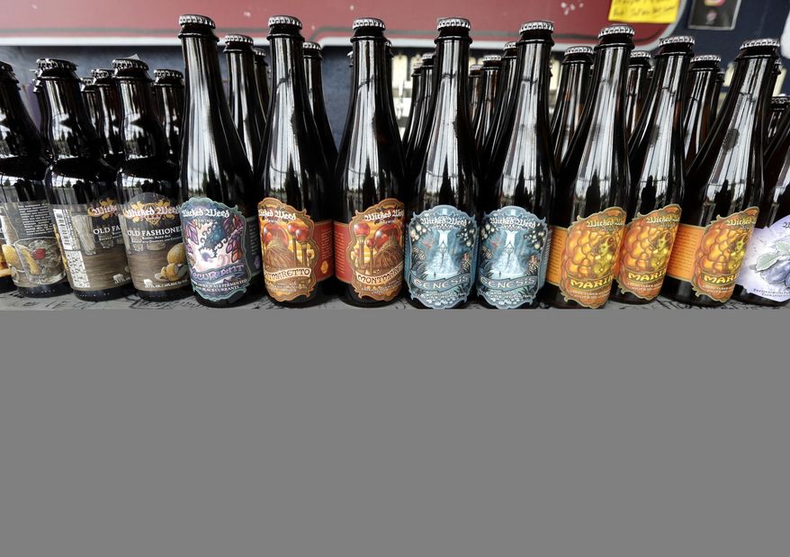 A sign against large beer companies is placed on the bar near bottles of Wicked Weed beer at Brawley's Beverage in Charlotte, N.C., Thursday, May 4, 2017. Brawley's is among at least a handful of stores or restaurants that announced they don't intend to stock Wicked Weed in the future.(AP Photo/Chuck Burton)