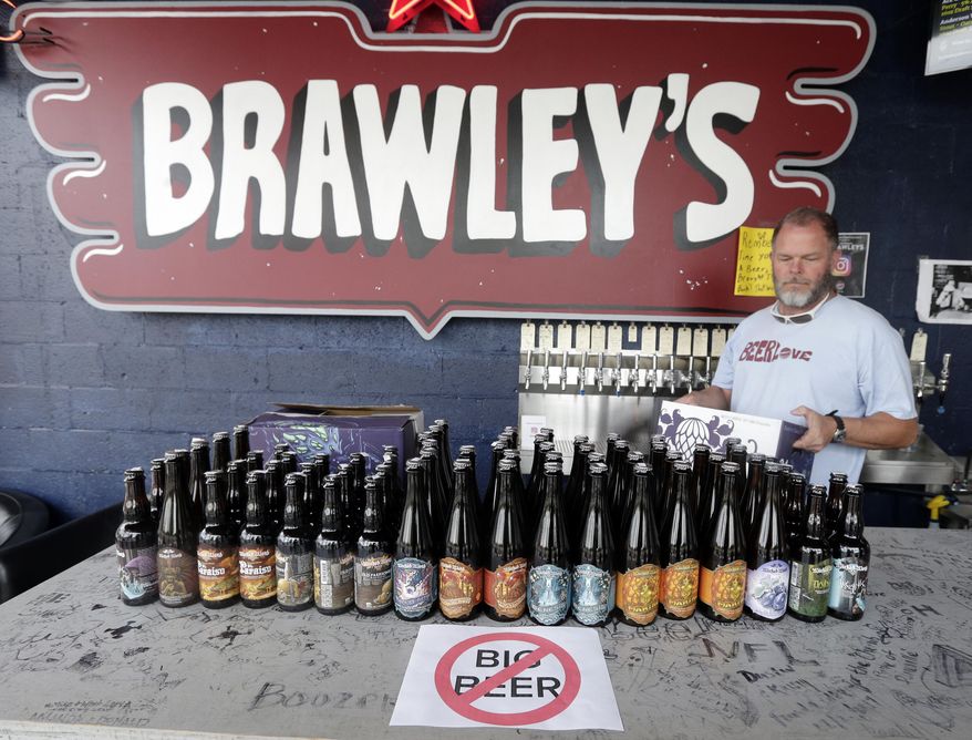 Michael Brawley carries his remaining bottles of Wicked Weed beer for sale at the bar at Brawley's Beverage in Charlotte, N.C., Thursday, May 4, 2017. Brawley is among at least a handful of stores or restaurants that announced they don't intend to stock Wicked Weed in the future.(AP Photo/Chuck Burton)