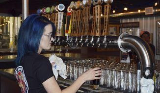 Maya Martinez, a manager at the Rio Bravo Brewing Company in Albuquerque, N.M., pours a craft beer on Wednesday, May 3, 2017, just days before the brewery was set to unveil a new beer on Cinco de Mayo. President Donald Trump&#39;s immigration policies and rhetoric are leaving some Mexican Americans and immigrants feeling at odds with a day they already thought was appropriated by beer and liquor companies, event promoters and local bars. (AP Photo/Russell Contreras)