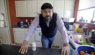 Jake Martinez, 32, looks on as he stands next to his medication at his home Thursday, May 4, 2017, in Murray, Utah. Martinez, who has epilepsy, is worried about health insurance as Republicans move closer to dismantling the Obama health care system, known as the Affordable Care Act, which he and his wife use. (AP Photo/Rick Bowmer)