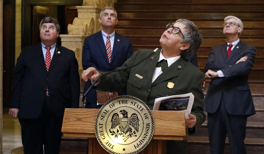 Kathleen Bond, superintendent of the Natchez National Historical Park, speaks about the 750 light fixtures that ring the rotunda at the Mississippi Capitol as she and several elected officials, including Gov. Phil Bryant, right, look at their placement prior to celebrating the facility being designated a national historic landmark, Thursday, May 4, 2017, in Jackson, Miss. (AP Photo/Rogelio V. Solis)