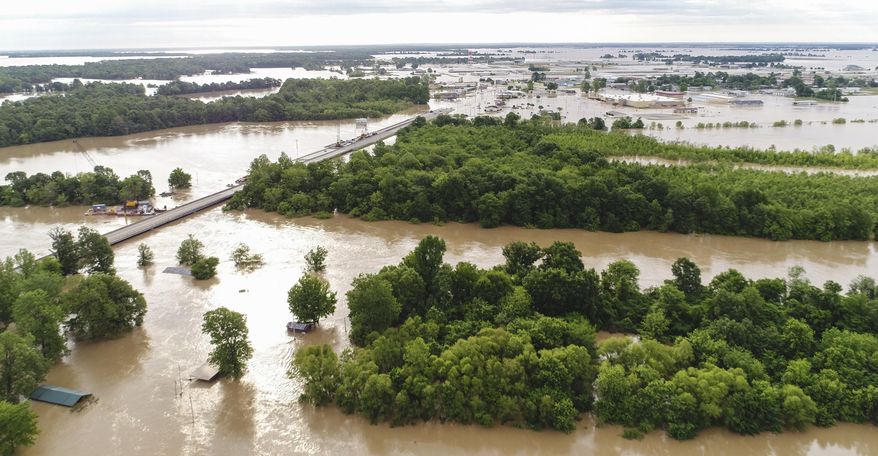 The murky waters of the Black River swell out of their banks in this view looking east with U.S. 67, at left, Wednesday, May 3, 2017, in Pocahontas, Ark. Downpours that dumped up to a foot of rain in parts of the nation’s midsection last weekend led to the sudden surge of water. (Stephen B. Thornton/The Arkansas Democrat-Gazette via AP)