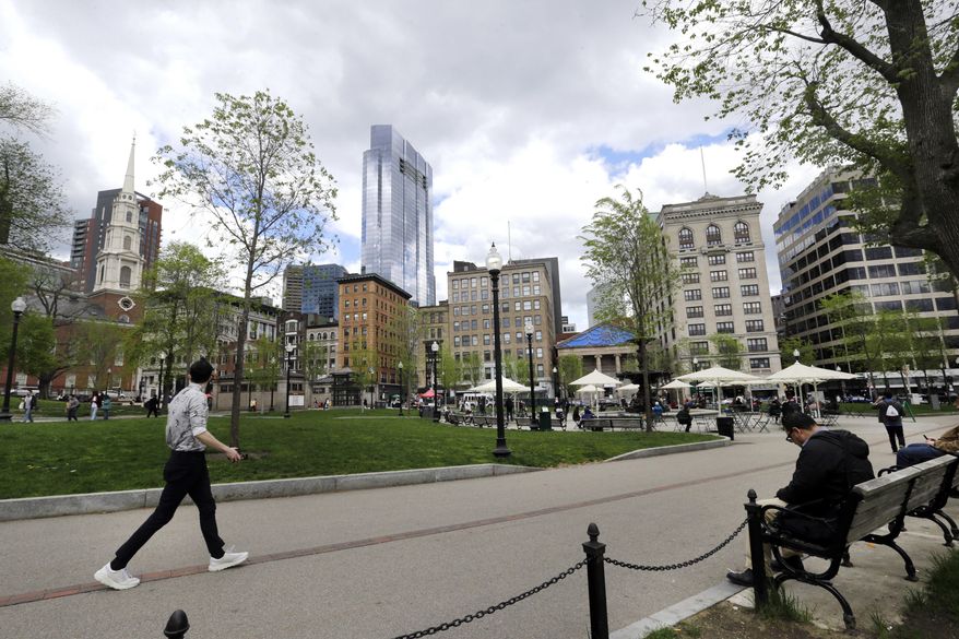 In this May 3, 2017 photo, people sit and walk in the Boston Common, a park surrounded by buildings in downtown Boston. A city that has seen its share of strife, from the school desegregation to the gentrification of its working classed neighborhoods, now finds itself embroiled in a new battle over a skyscraper shadow and two cherished public parks, Boston Common and the neighboring Public Garden. At issue is whether developers of the proposed tower should be allowed to violate a state law banning buildings from casting shadows over historic parks. (AP Photo/Elise Amendola)