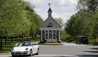 In this Tuesday, May 2, 2017, photo cars drive near the entrance to Trump National Golf Club Bedminster in Bedminster, N.J. Trump is expected to make regular weekend visits this summer to Bedminster. Bedminster is known for its rolling hills, horse farms and mostly two-lane roads. (AP Photo/Seth Wenig)
