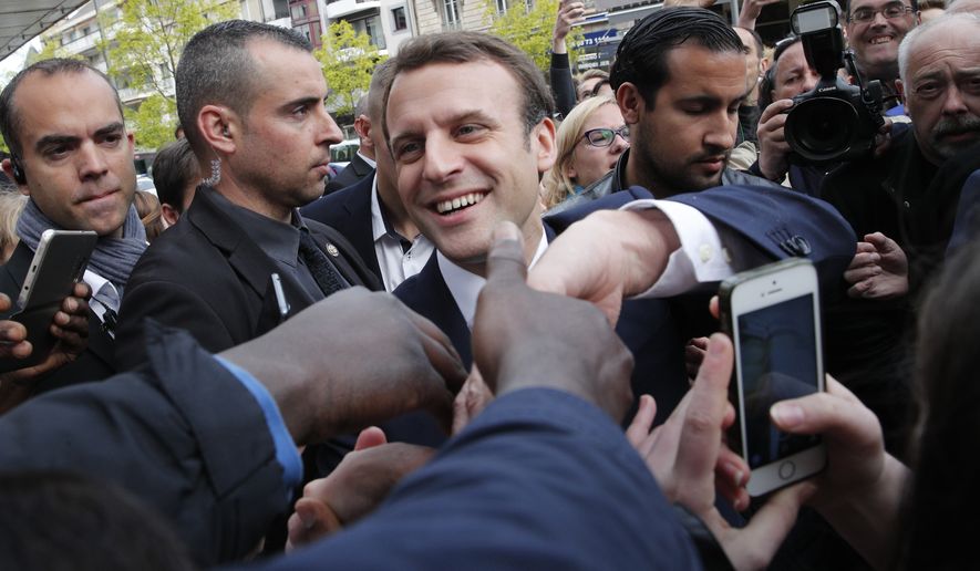 French independent centrist presidential candidate Emmanuel Macron shakes hands to supporters as he campaigns in Rodez, southern France, Friday, May 5, 2017. The 39-year-old independent candidate faces far-right National Front leader Marine Le Pen in Sunday&#39;s presidential runoff. (AP Photo/Christophe Ena)