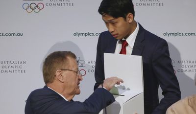 Australian Olympic Committee President John Coates, left, casts his ballot for his re-election during the AOC&#39;s annual general meeting in Sydney, Saturday, May 6, 2017. Coates will serve another four-year term as president of the Australian Olympic Committee after beating former field hockey gold medalist Danni Roche by a landslide in an election. (AP Photo/Rick Rycroft)