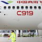In this Thursday, May 4, 2017 photo, a worker walks past a COMAC C919 aircraft in an airplane hangar in Shanghai. China&#39;s first large homemade passenger jetliner is due to make its maiden flight from Shanghai later Friday. (Chinatopix via AP)