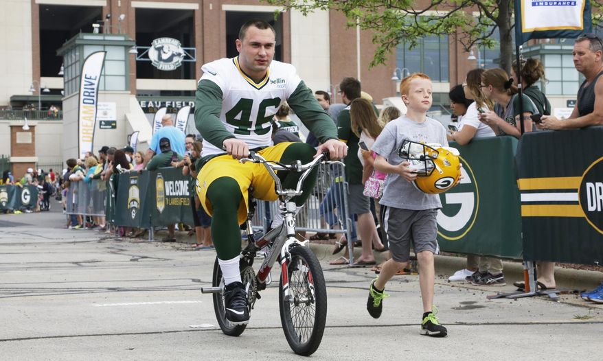FILE - In this July 26, 2014, file photo, Green Bay Packers' Colt Lyerla rides a bike to NFL football training camp in Green Bay, Wis. Lyerla, who had been sentenced to six months in jail after admittedly using fake bills at a 7-Eleven and a deli, has escaped from Washington County custody, and a warrant has been issued for his arrest, officials said Friday, May 5, 2017. (AP Photo/Morry Gash, File)