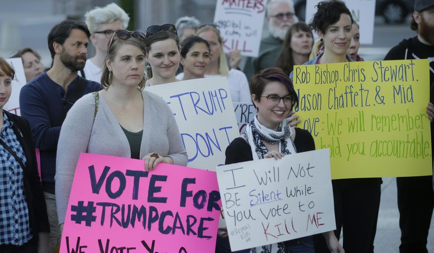 People look on during a healthcare rally Thursday, May 4, 2017, in Salt Lake City. Utah's all-Republican House delegation voted Thursday in favor of a health care overhaul that could impact people with pre-existing conditions, triggering serious worries from people who fit that category. (AP Photo/Rick Bowmer)