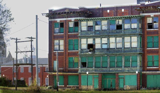 FILE - This Oct. 13, 2015 file photo shows abandoned buildings which dominate downtown in Cairo, Ill. A federal government plan to tear down the crumbling public housing complex in the southern Illinois town of Cairo has sent roughly 200 families searching for new homes and sparked fears that the once-thriving river city could be coming to an end. (AP Photo/Seth Perlman File)