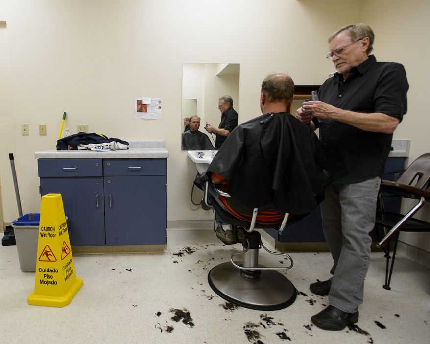 In this April 17, 2017, photo Stuart Stone cuts Brad Rubsam's hair at the Weigland Center in Salt Lake City. Stone as been volunteering his services giving haircuts to homeless individuals for some 20 years. (Steve Griffin/The Salt Lake Tribune via AP)