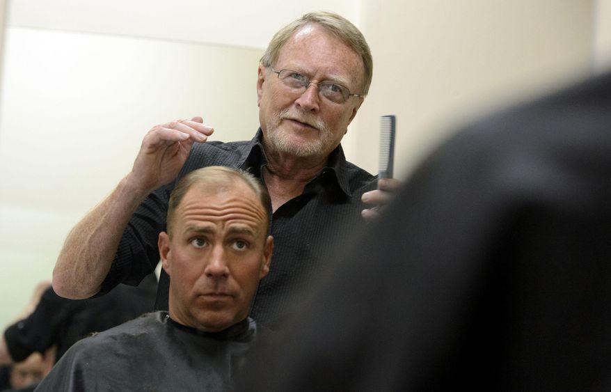 In this April 17, 2017, photo Stuart Stone cuts Brad Rubsam's hair at the Weigland Center in Salt Lake City. Stone as been volunteering his services giving haircuts to homeless individuals for some 20 years. (Steve Griffin/The Salt Lake Tribune via AP)