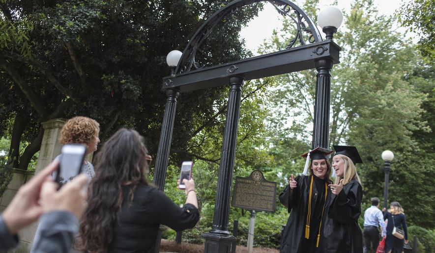 Soon-to-be graduates, Callie Rittweger, left, and Ashley Owen, right, from the University of Georgia's Franklin College of Arts communications program, pose for photos at the Arch, Thursday, May 04, 2017. The university will be having its graduation ceremony May 5 at Sanford Stadium. Georgia Governor Nathan Deal signed legislation allowing guns on Georgia's college campuses today also. (John Roark/ Athens Banner-Herald via AP)