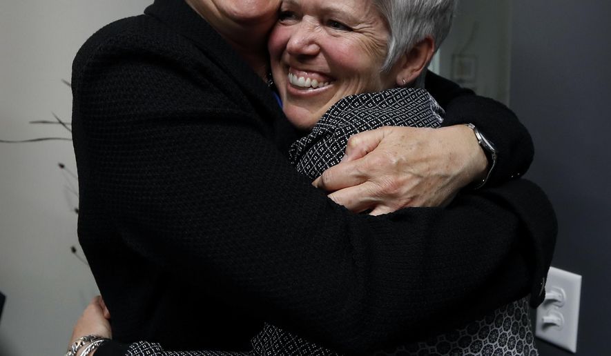Jane Meyer, former senior associate athletic director at the University of Iowa, gets a hug from her partner Tracey Griesbaum, right, following a news conference, Thursday, May 4, 2017, in Des Moines, Iowa. A jury on Thursday awarded more than $1.4 million to Meyer ruling that the university had discriminated against her because of her gender and sexual orientation. (AP Photo/Charlie Neibergall)