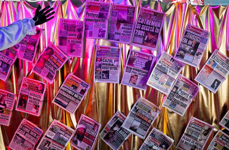 In this Thursday, May 4, 2017, copies of the now-defunct Dracula weekly one showing a front page headline that reads "Extraterrestrials steal electricity." at the newly opened Bucharest Kitsch Museum, in Bucharest, Romania. The Kitsch Museum opens for visitors on Friday, May 5, 2017. (AP Photo/Vadim Ghirda)