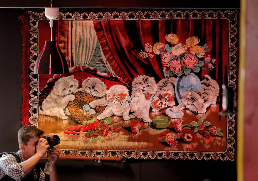 In this Thursday, May 4, 2017, photo a news photographer works inside the newly opened Bucharest Kitsch Museum, in Bucharest, Romania. The Kitsch Museum opens for visitors on Friday, May 5, 2017. (AP Photo/Vadim Ghirda)