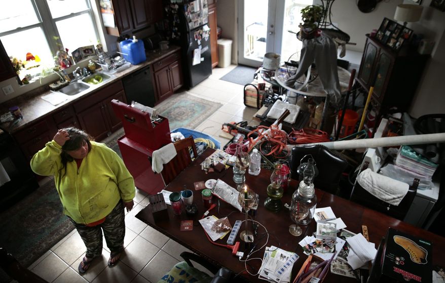 Tammy Neeley and her husband Jonathan moved all of their belongings from their garage into their home and stayed through the flood in downtown Pacific on Thursday, May 4, 2017. The Neeley's lifted their home 9 feet with the help of a grant in 2008 after a previous flood. Pacific officials estimate 170 homes and businesses were flooded. (Robert Cohen/St. Louis Post-Dispatch via AP)