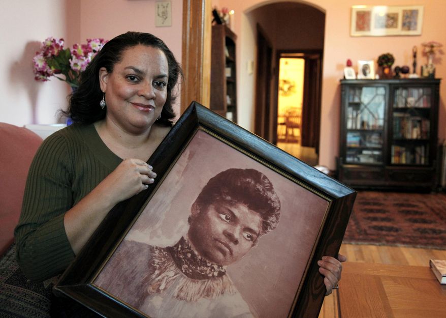 FILE - In this Dec. 2, 2011 file photo, Michelle Duster, great-granddaughter of civil rights pioneer Ida B. Wells who led a crusade against lynching during the early 20th century, holds a portrait of Wells in her home in Chicago's South Side. Historically, black women have been no strangers to the quest for social change. But historians say they have often been overshadowed, first by white women during the suffragette movement and then by the black men who were lionized during the civil rights movement. A new generation of black women is now moving to take and keep a place at the forefront of the fight against racial bias. (AP Photo/Charles Rex Arbogast, File)