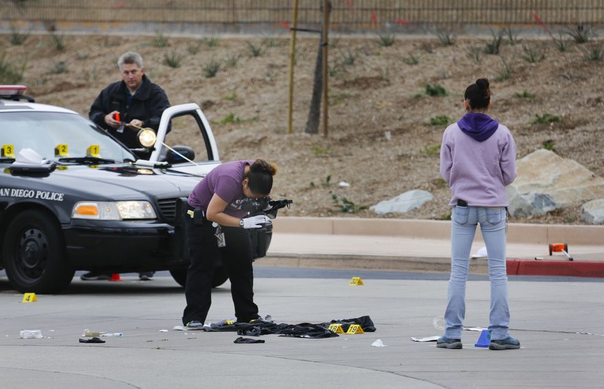 Members of the San Diego Police Department collect evidence at the scene of a fatal police officer involved shooting of a 15-year-old boy in one of the parking lots in front of Torrey Pines High School, early Saturday morning. The boy reportedly called the police and when they arrived pointed what appears to be a gun at them. (Howard Lipin/The San Diego Union-Tribune via AP)