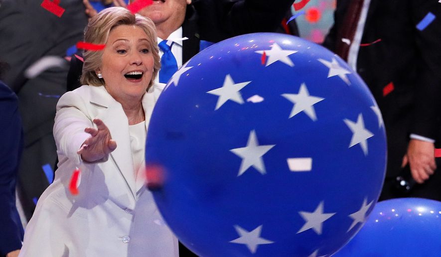 Then-presidential nominee Hillary Clinton reaches for a falling balloon at the conclusion of the 2016 Democratic National Convention in Philadelphia. (Associated Press) ** FILE **