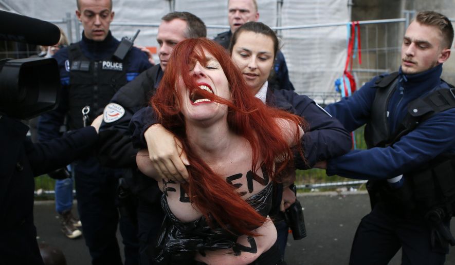 A Femen activist is led away by French police in Henin-beaumont, northern France, Sunday, May 7, 2017. Voters across France are choosing a new president in an unusually tense and important election that could decide Europe&#39;s future, making a stark choice between pro-business progressive candidate Emmanuel Macron and far-right populist Marine Le Pen. (AP Photo/Francois Mori)