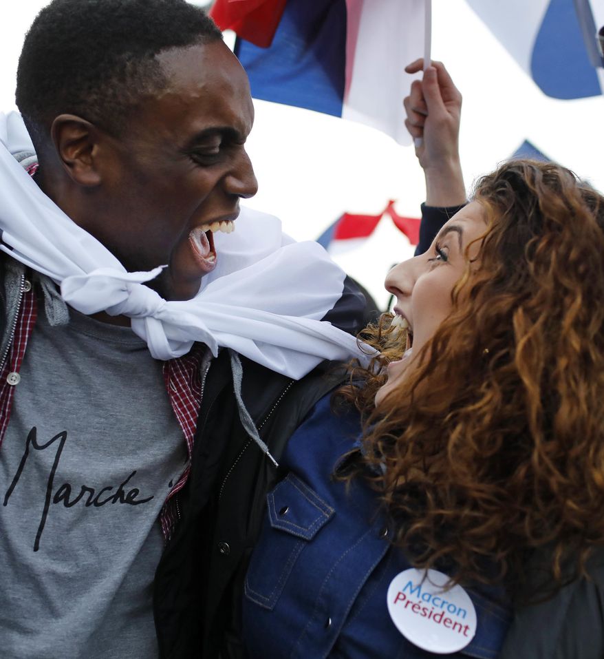 Supporters of French independent centrist presidential candidate, Emmanuel Macron react outside the Louvre museum in Paris, France, Sunday, May 7, 2017. Polling agencies have projected that centrist Emmanuel Macron will be France&#39;s next president, putting a 39-year-old political novice at the helm of one of the world&#39;s biggest economies and slowing a global populist wave. The agencies projected that Macron defeated far-right leader Marine Le Pen 65 percent to 35 percent on Sunday. (AP Photo/Laurent Cipriani)