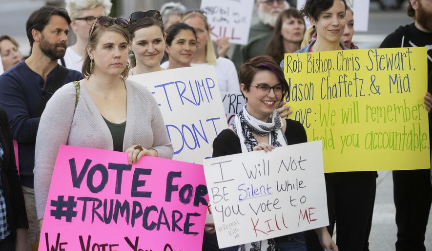 FILE - In this Thursday, May 4, 2017 file photo, demonstrators hold signs during a healthcare rally in Salt Lake City. Utah's all-Republican House delegation voted Thursday in favor of a health care overhaul that could impact people with pre-existing conditions, triggering serious worries from people who fit that category. (AP Photo/Rick Bowmer)