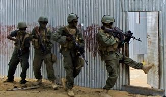 Masked Somali national army (SNA) soldiers search through homes for al-Shabaab fighters during an operation in Ealsha Biyaha, Somalia, on June, 2, 2012. (Associated Press) **FILE**
