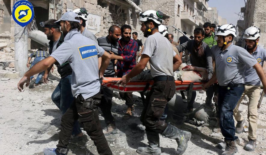 In this photo provided by the Syrian Civil Defense White Helmets, rescue workers work the site of airstrikes in  the al-Sakhour neighborhood of the rebel-held part of eastern Aleppo, Syria, Wednesday Sept. 21, 2016. Ibrahim Alhaj, a member of the volunteer first responders known as the Syria Civil Defense, said 24 people were killed in a series of bombings in several parts of the besieged city Aleppo on Wednesday.  (Syrian Civil Defense White Helmets via AP)