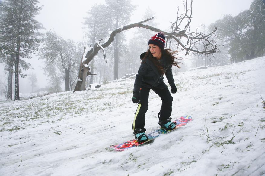 Makenna Aragon snowboards down a hill on Mount Laguna, Calif., Sunday, May 7, 2017. A spring storm hit Southern California on Sunday with gusty winds, thunderstorms and pea-size hail stones, prompting everything from the postponement of a baseball game to the sight of celebrities at a red-carpet ceremony scrambling for cover. (Nelvin C. Cepeda/The San Diego Union-Tribune via AP)