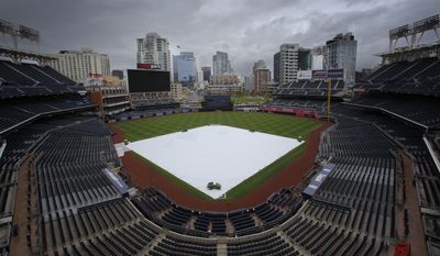 The a tarp covers the infield at Petco Park, Sunday, May 7, 2017, in San Diego. A spring storm hit Southern California on Sunday with gusty winds, thunderstorms and pea-size hail stones, prompting everything from the cancellation of a baseball game to the sight of celebrities at a red-carpet ceremony scrambling for cover. (Nelvin C. Cepeda/The San Diego Union-Tribune via AP)