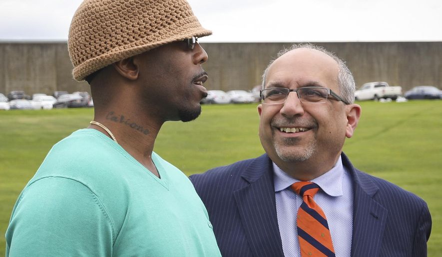 Calvin Buari, left, talks with his lawyer Oscar Michelen following his release from Green Haven correctional facility, shown in background, Monday, May 8, 2017, in Stormville, N.Y. Buari, who spent 22 years in prison for a double killing he said he didn't do, was freed after his conviction was overturned.(AP Photo/Bebeto Matthews)