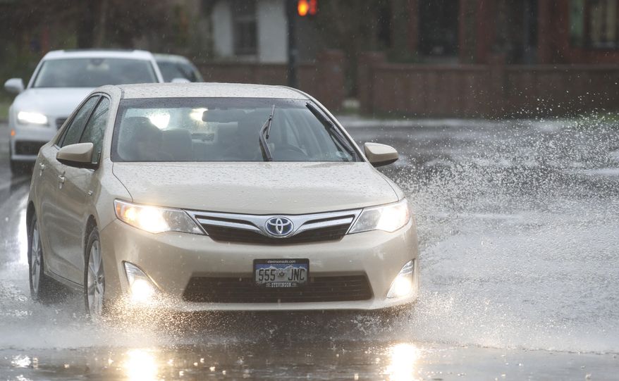 A motorist guides his car through a puddle along Speer Boulevard as a spring storm, packing high winds, heavy rains and hail, sweeps over Colorado's Front Range just before the afternoon rush hour Monday, May 8, 2017, in Denver. (AP Photo/David Zalubowski)