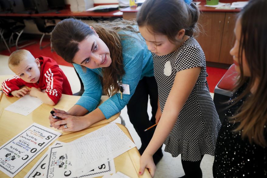 In this Wednesday, March 29, 2017, photo, language arts teacher Jennifer Walters helps students with their homework during an after-school program at Circleville Elementary School, in Circleville, Ohio. Supporters of after-school programs in places like Circleville, and Concord, N.H., said the study help, social skill-building and supervision they provide is at stake if President Donald Trump’s administration cuts the main federal funding for such programs. (AP Photo/John Minchillo)