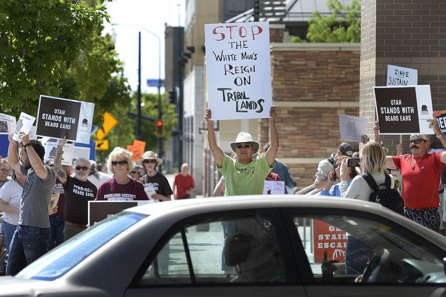 Protesters chant in favor of the Bears Ears National Monument as vehicles leave the Gateway Shopping Mall near the Bureau of Land Management office, where U.S. Interior Secretary Ryan Zinke were speaking at a news conference in Salt Lake City, Sunday, May 7, 2017. Zinke met with tribal leaders and elected officials as he kicked off a four-day trip to the state to inspect two disputed national monuments protecting more than 3 million combined acres of the state's red rock country. (Scott Sommerdorf/The Salt Lake Tribune via AP)