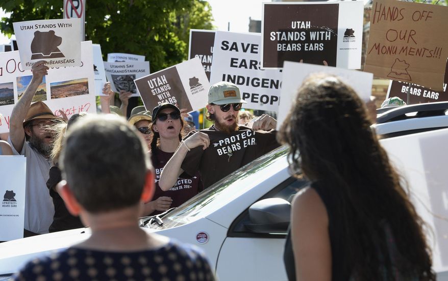 Protesters chant in favor of the Bears Ears National Monument as vehicles leave the Gateway Shopping Mall near the Bureau of Land Management office, where U.S. Interior Secretary Ryan Zinke was speaking at a news conference in Salt Lake City, Sunday, May 7, 2017. Zinke met with tribal leaders and elected officials as he kicked off a four-day trip to the state to inspect two disputed national monuments protecting more than 3 million combined acres of the state's red rock country. (Scott Sommerdorf/The Salt Lake Tribune via AP)