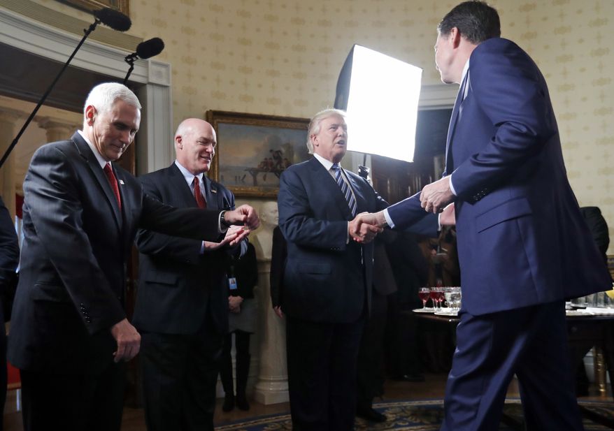 Vice President Mike Pence, left, and Secret Service Director Joseph Clancy stand as President Donald Trump shakes hands with FBI Director James B. Comey during a reception for inaugural law enforcement officers and first responders in the Blue Room of the White House, Sunday, Jan. 22, 2017 in Washington. (AP Photo/Alex Brandon) ** FILE **