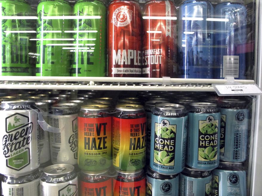 Different varieties of Vermont craft beer sit in a store cooler at Mehuron's Market on Tuesday, May 9, 2017, in Waitsfield, Vt. Vermont brewers have a message for the rest of the industry: don't go describing a brew as a Vermont beer if it's not from the Green Mountains. (AP Photo/Lisa Rathke)