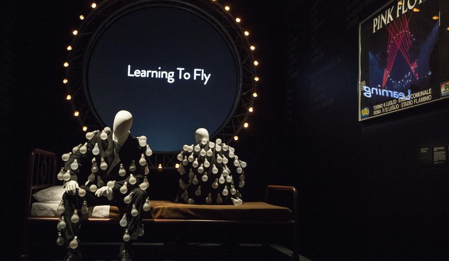 Mannequins in 'a lightbulb suit' are photographed in front of a 'Learning to Fly' display at the Pink Floyd exhibition 'Their Mortal Remains' at the V&A museum in west London, Tuesday, May 9, 2017, an immersive, experimental journey through Pink Floyd's world of over 350 objects and artefacts from the band. The exhibition marks the 50th anniversary of the band's first album, 'The Piper At The Gates Of Dawn' and officially opens to the public on 13 May (Photo by Joel Ryan/Invision/AP)