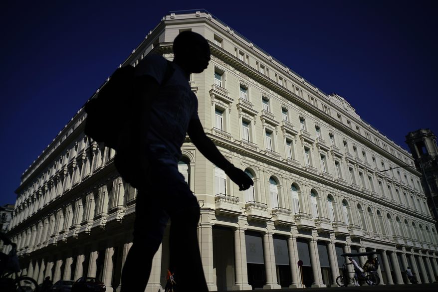 A man walks in front of the Manzana de Gomez Kempinski five-star hotel in Havana, Cuba, Monday, May 8, 2017. In the heart of the capital of a nation founded on ideals of social equality, the business arm of the Cuban military has transformed a century-old shopping arcade into a temple to conspicuous capitalism. The five-story Manzana sits off the Prado, the broad, tree-lined boulevard that divides the colonial heart of the city. The upper floors are a five-star hotel opening in early June that is owned by the military’s tourism arm, Gaviota, and run by Swiss luxury chain Kempinski. (AP Photo/Ramon Espinosa)