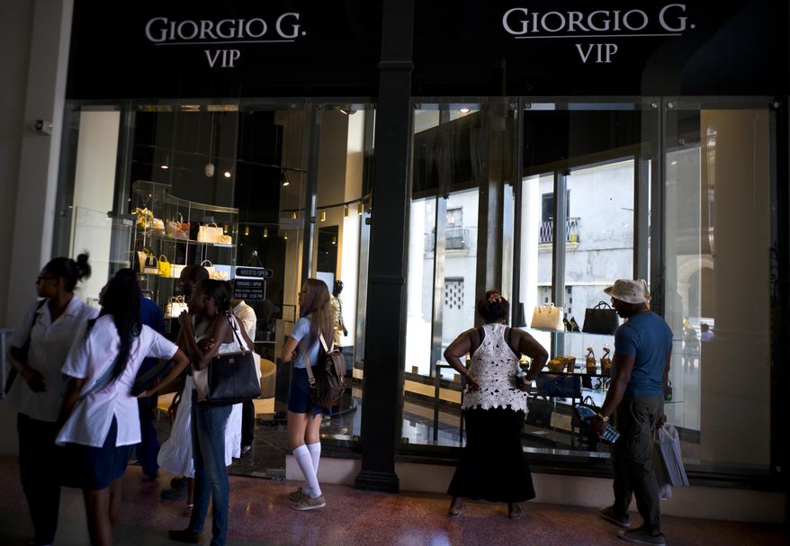 People look at the storefront window of a luxury store at the Manzana de Gomez Kempinski five-star hotel in Havana, Cuba, Monday, May 8, 2017. The hotel is earning positive early reviews but many tourists say they find the luxury mall alongside it to be repulsive. (AP Photo/Ramon Espinosa)