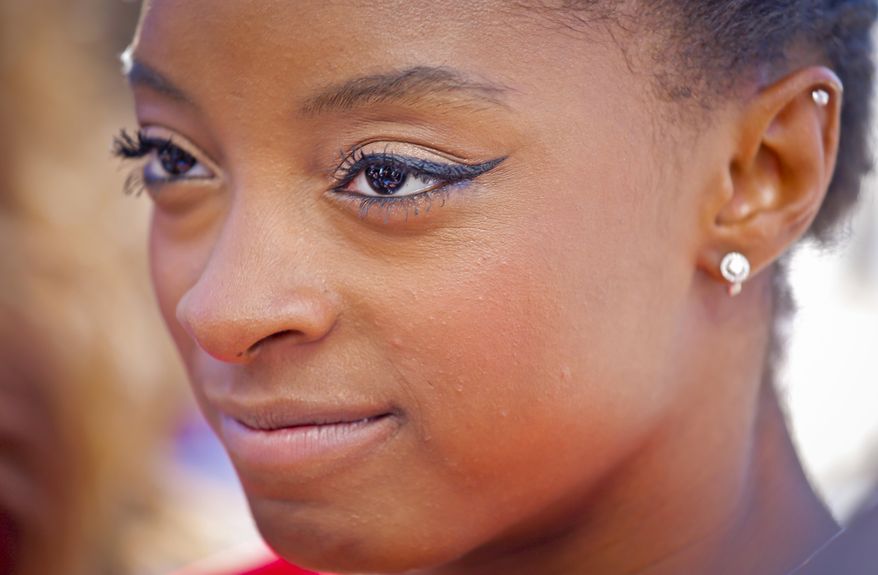 FILE - In this Aug. 23, 2016, file photo, U.S. Olympic gold medalist gymnast Simone Biles listens during an interview at the Empire State Building in New York. The Olympic champion gymnast stood tightlipped while receiving feedback from judge Carrie Ann Inaba following her performance on the Monday, May 8, 2017, edition of “Danciing with the Stars.” When host Tom Bergeron asked Biles why she didn’t smile while hearing some of the praise from Inaba, Biles grinned and said, “smiling doesn’t win you gold medals.” (AP Photo/Bebeto Matthews, File)