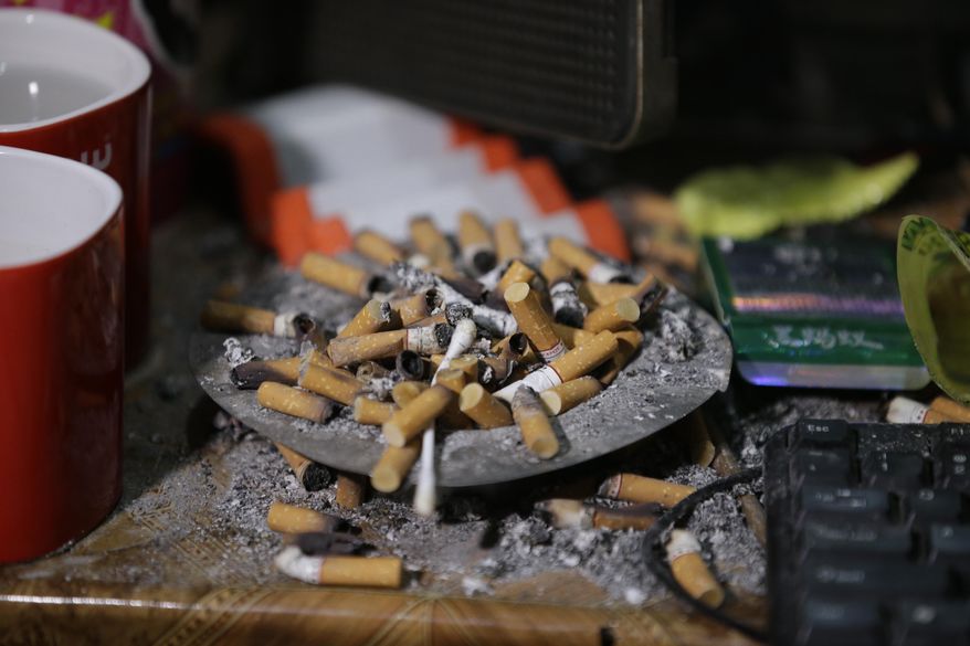 In this April 20, 2017, photo, cigarettes overflow from an ashtray inside the home of suspected child webcam cybersex operator, David Timothy Deakin, from Peoria, Ill., during a raid in Mabalacat, Philippines. Children's underwear, toddler shoes, cameras, bondage cuffs, fetish ropes, meth pipes, stacks of hard drives and photo albums cluttered the stuffy, two-bedroom townhouse. In his computer files, there were videos and images of children engaged in sex acts. (AP Photo/Aaron Favila)