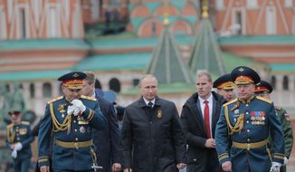 Russian Defence Minister Sergei Shoigu, left, Russian President Vladimir Putin, center, and Russian army Gen. Oleg Salyukov, right, walk along the Red Square during the Victory Day military parade to celebrate 72 years since the end of WWII and the defeat of Nazi Germany, in Moscow, Russia, on Tuesday, May 9, 2017. (Yuri Kochetkov/Pool photo via AP)